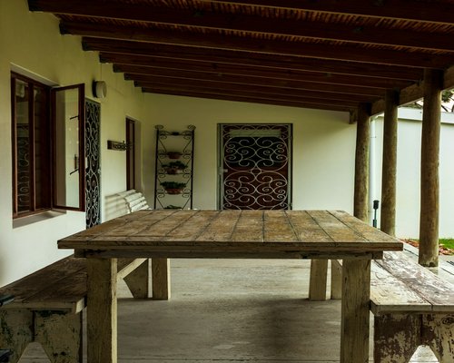 A serene view of a wooden porch with lush tropical garden in the background